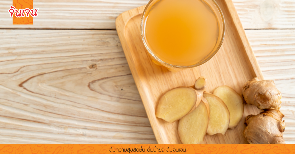 น้ำขิงสดและขิงหั่นบนเขียงไม้